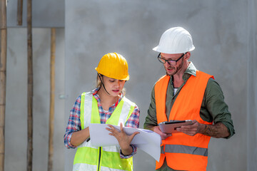 Engineering Consulting People on construction site holding blueprint in his hand. Building inspector. Construction site check drawing and business workflow of new building