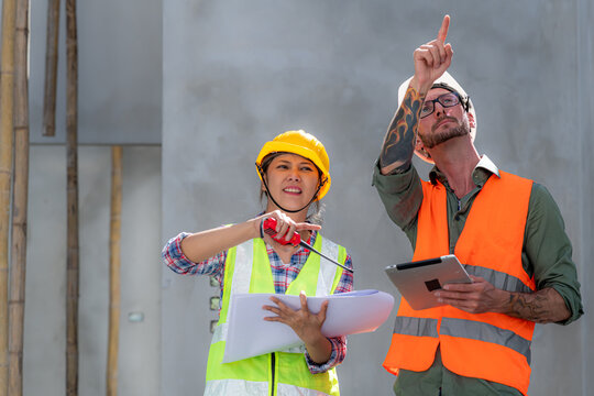 Construction engineers discussion with architects at construction site or building site of highrise building