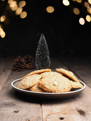 Tasty organic oat cookies on a wooden table with Christmas lights