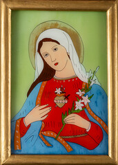 Icon painted on reverse glass depicting the immaculate heart of Virgin Mary holding a branch of white lilies. Roman Catholic devotional icon in a golden frame.