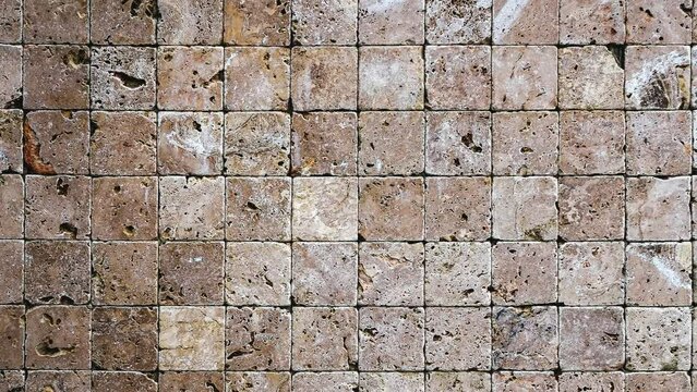Square stones surface background Seamless Loop. Travertine masonry tiles cladding wall texture.