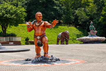Orange giant statue standing holding an ax and put your hand forward