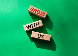 Grow with us symbol. Wooden blocks with words Grow with us. Beautiful green background. Business and Grow with us concept. Copy space.