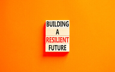 Building a resilient future symbol. Concept word Building a resilient future on wooden blocks. Beautiful orange table orange background. Business and building a resilient future concept. Copy space.