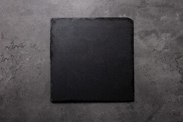 slate cutting board on dark stone background