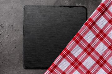 slate cutting board on dark stone background with red and white checkered cloth