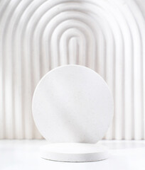 A minimalistic scene of a gypsum podium with stones on white background, for natural cosmetics