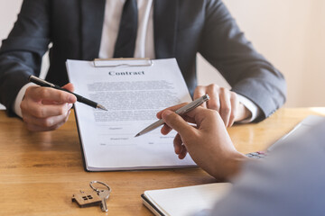 Financial, asian man lease landlord, agent banker or bonding hand is pointing to contract of tenant, new owner or renter of home to sign signature on purchase, rental property. Estate mortgage.