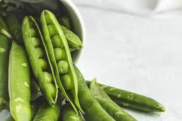 Raw green pea pods on light background