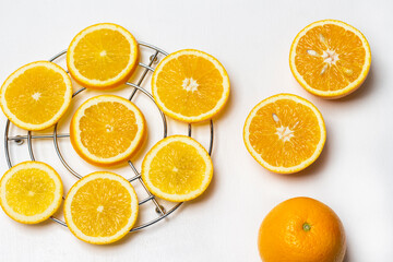 Sliced orange slices on a metal stand. Two halves and a whole orange.