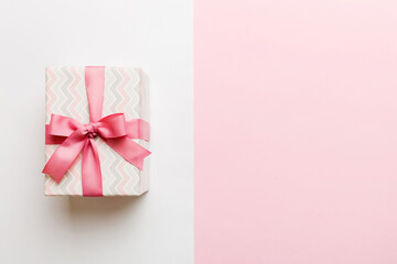 holiday paper present tied pink ribbon bow top view with copy space. Flat lay holiday background. Birthday or christmas present. Christmas gift box concept with copy space
