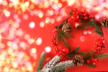 Festive Christmas wreath ornaments and decorations on red background.