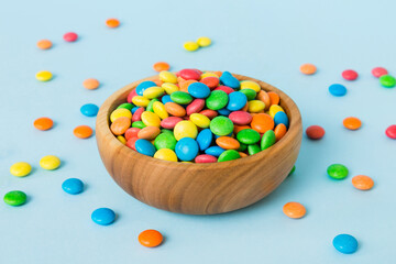 Multicolored candies in a bowl on a colored background. birthday and holiday concept. Top view with...