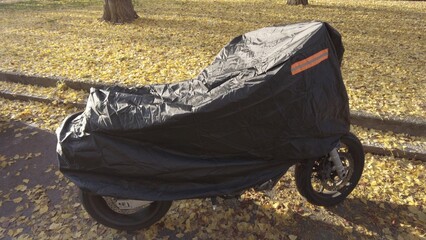 tarpaulin to cover the motorcycle and protect it from the cold in winter and from the sun in summer - universal rain cover - obrazy, fototapety, plakaty