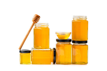 jars with honey one on top of the other and a stick for honey on a white background