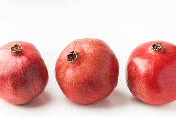 Fototapeta na wymiar Fresh whole pomegranate fruits isolated on white background. Ripe pomegranates with glossy red peel