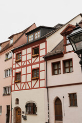 Fototapeta na wymiar Old historic architecture in Nuremberg, Germany. Traditional European old town buildings with wooden windows, shutters and colourful pastel walls. Aesthetic summer vacation, tourism background