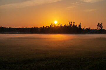 Obraz na płótnie Canvas Sunset over a foggy field. Nykarleby/Uusikarlepyy, Österbotten/Pohjanmaa. Finland