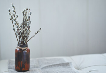A bouquet of willow on the edge of the table. Willow, fluffy buds, brown glass vase. Happy Easter concept with copy space. High quality photo