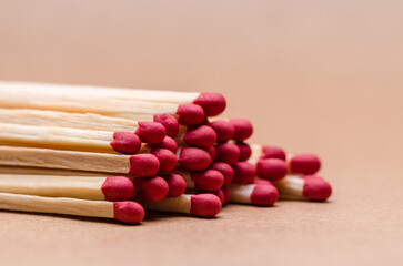 Close-up macro of a pile of new unlit wooden matchsticks on natural brown paper background
