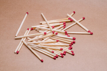 Close-up macro of a pile of new unlit wooden matchsticks on natural brown paper background