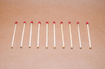 New unlit wooden matchsticks orderly aligned on natural brown background