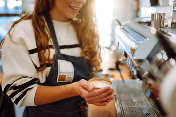 Barista waitress holding a white-hot coffee cup. Food and drink concept.