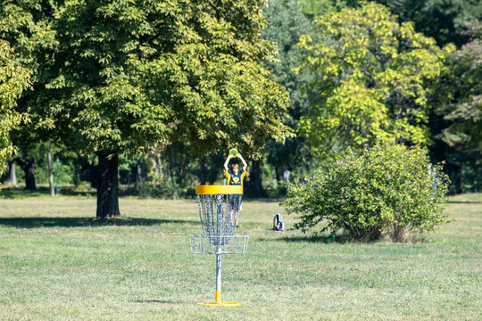 Disc golf player playing a flying disc sport game in the park or nature