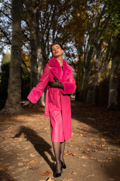 Transsexual guy with makeup standing in park with closed eyes
