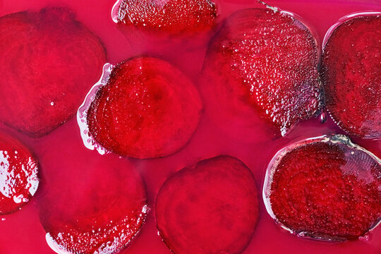 Background of slices of beet on fuchsia surface