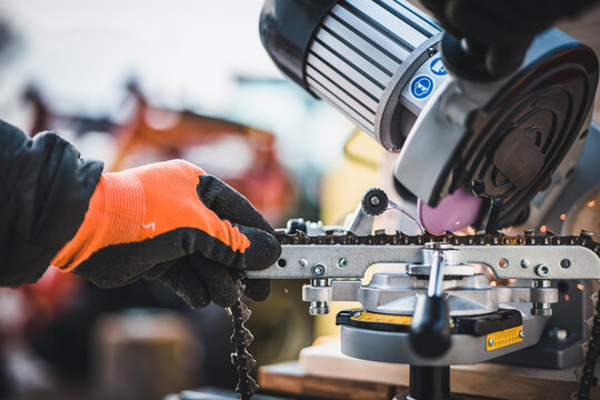 Sharpening motor chain or chainsaw chain with the use of a motorized grinder. Professional repairman sharpening a chain. Sharpening a chainsaw.