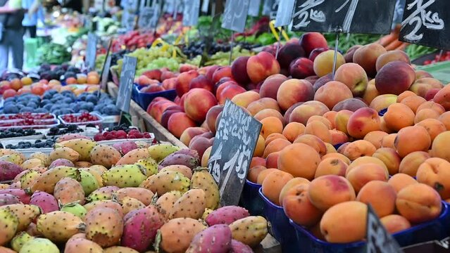 Vienna, Austria, August 2022. At the Naschmarkt market slow motion close-up image with seasonal fruit on display. Apricots, prickly pears, peaches.