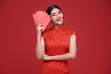 Happy Chinese new year. Asian woman holding angpao or red packet monetary gift and gold ingot...
