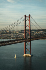 25 de Abril Bridge, Red Bridge in Lisbon Portugal, Looks Like Golden Gate Bridge in San Francisco, USA, With a Boat Below it