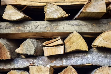 Foto op Aluminium Gehakt brandhout wordt in nette stapels gestapeld. Houtstapel. Achtergrond. Detailopname. Selectieve focus. © Marina_Nov