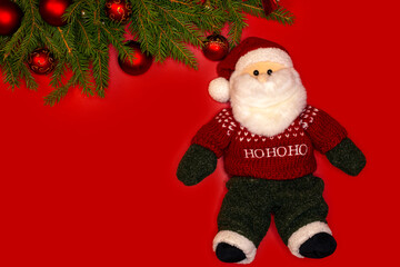 Christmas tree with decorations and Santa Claus. On a red background.