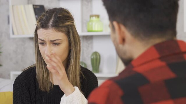 Bad breath. Young woman disgusted because her boyfriend's breath has strong odor.
Bad breath. Woman covers her nose and turns away.

