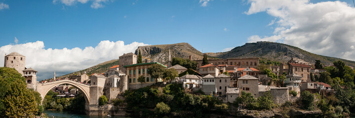 Balkan town with medieval bridge and hills in background