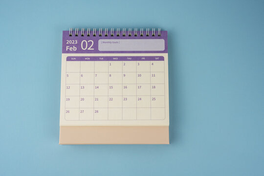 February 2023 desk calendar on blue background flat lay
