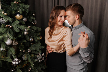 Young couple in love decorating the Christmas tree together
