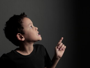 Obraz premium child pointing and reaching up to the sky on white background with people