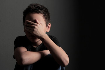 boy praying to God with hands together with black background stock photo	