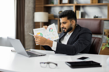 Video call conference meeting conversation online. Young bearded businessman teacher freelancer showing explaining graphs charts tables on laptop to colleagues, e-learning on lectures at office