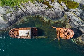 Foto op Canvas Stranded transport ship destroyed on the cliffs of a remote island after an accident © Photofex