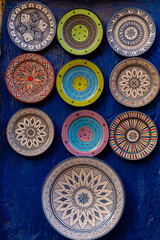 handmade clay plates hanging on the wall in a essaouira (sawira) market in morocco