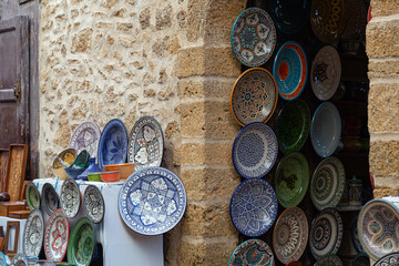 handmade clay plates hanging on the wall in a essaouira (sawira) market in morocco