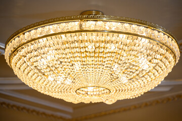 Close-up of beautiful crystal chandelier round shape hanging from the ceiling in the interior