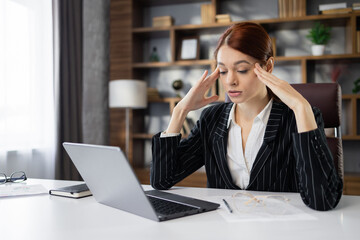 Stressed puzzled caucasian red hair businesswoman with closed eyes feeling headache, sitting in office, exhausted upset employee reading bad news in email, having problem with difficult online project