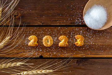 2023,Year 2023 written in letter bread. on the wood grain background.