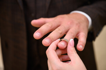 close-up of the hands, the bride puts on the ring to the groom